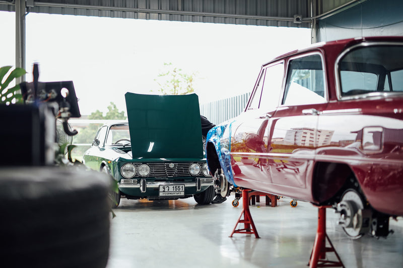 Classic green and red Alfa Romeo's in garage in Norway
