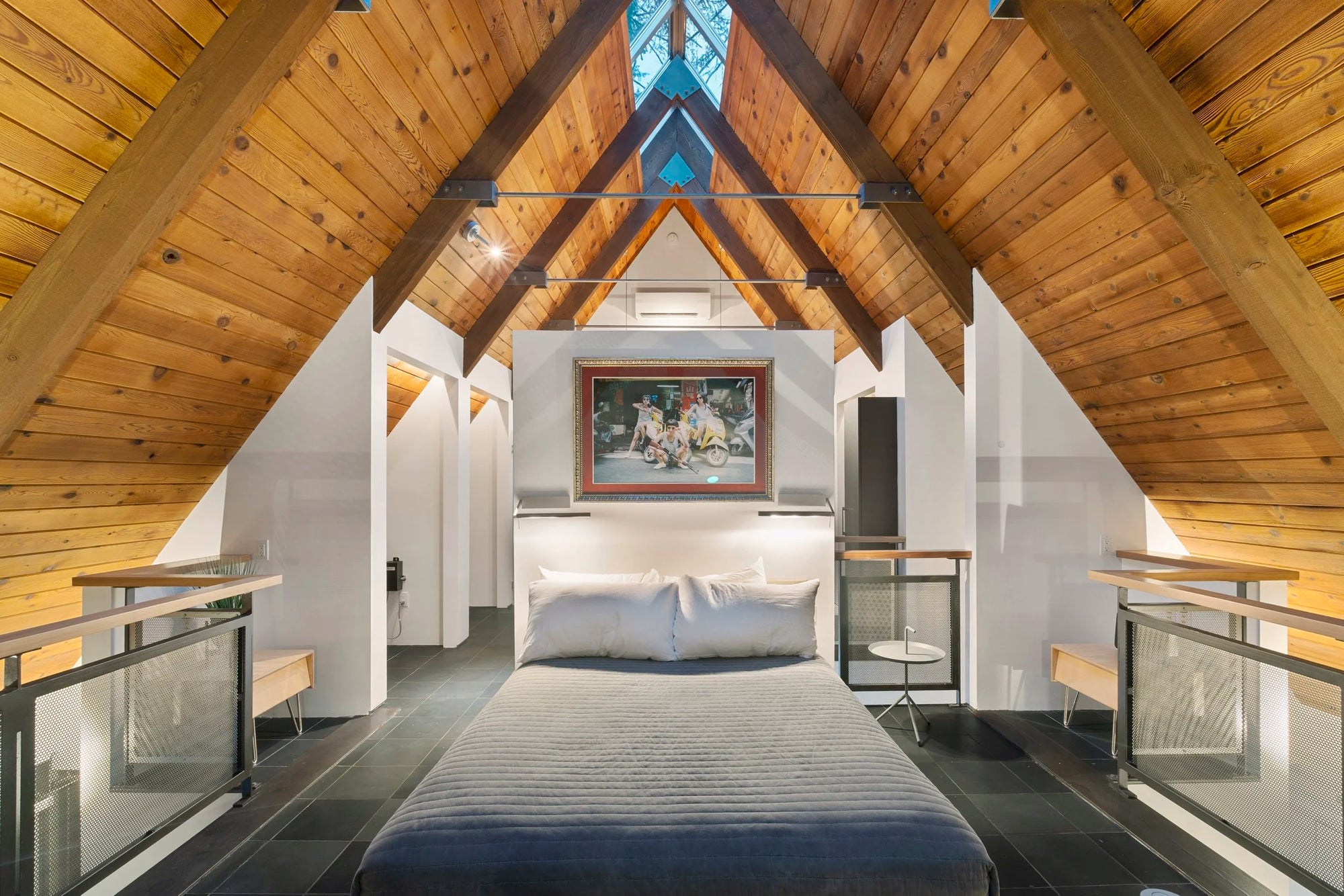 Modern bedroom with wooden beams and a large bed in Issaquah, WA, A-Frame home. 