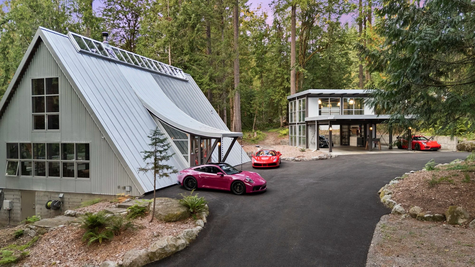 Modern industrial A-Frame house and large carport with Porsche and Ferrari cars in the drivewat. Nesteled in a lush forest in Issaquah, WA.