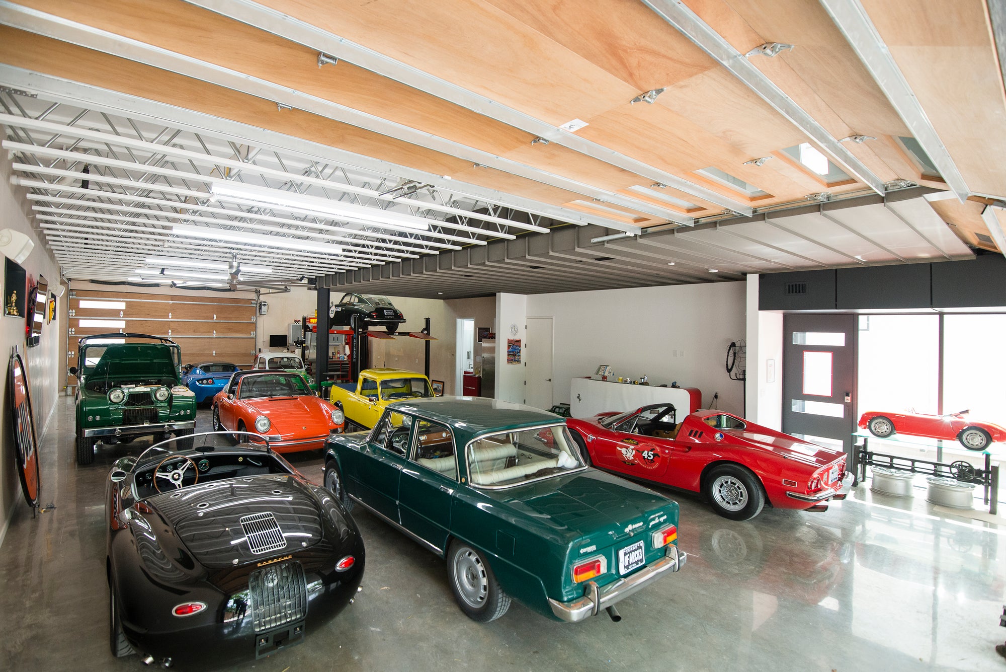 Wide shot of a luxury car collection in a modern garage at AUTOHAUS Austin, Texas.