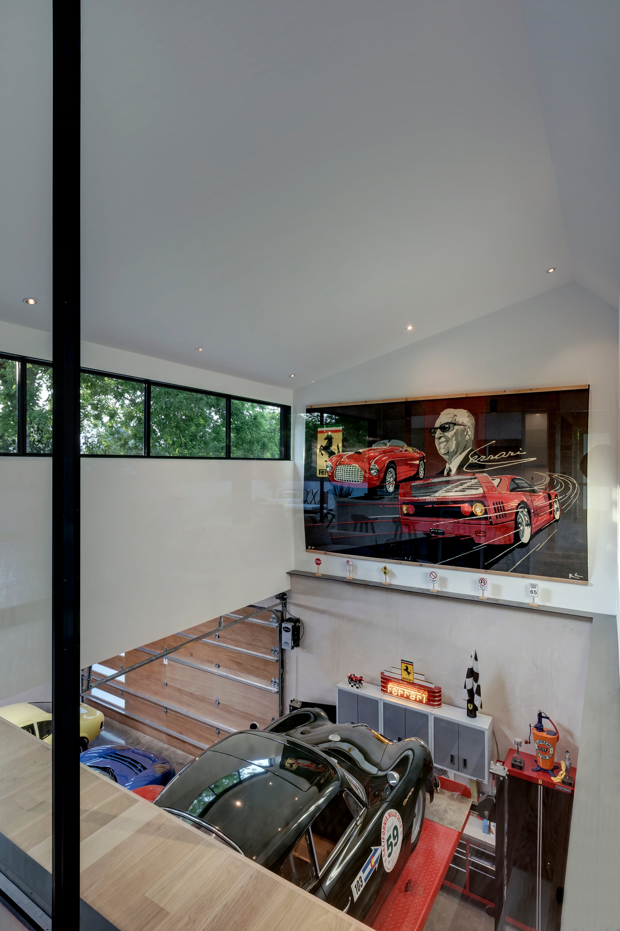 Luxury multi-level garage in Austin, TX, featuring classic cars, a Ferrari mural, and modern design.