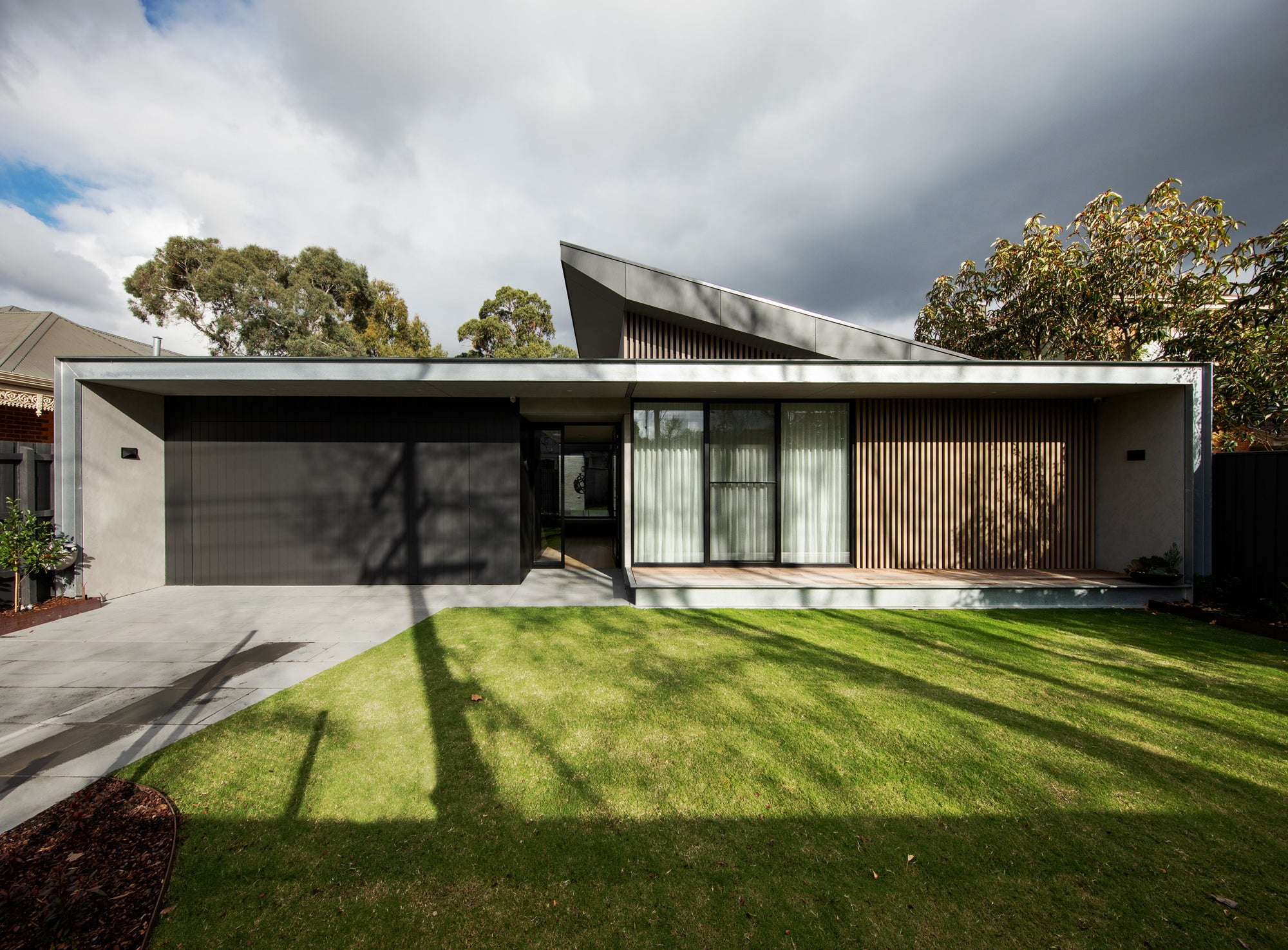 Side exterior view of Campbell St House showing angular roofline and dark garage door in Melbourne
