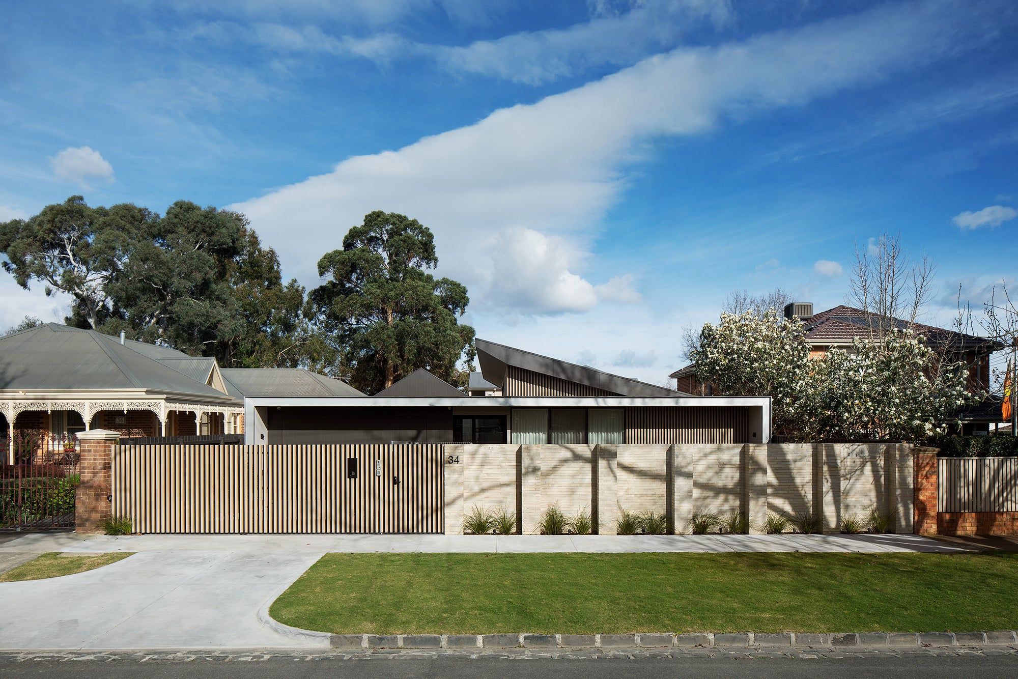 Street facade of Chan Architecture Campbell St House with handcrafted brick wall in Kew, Melbourne