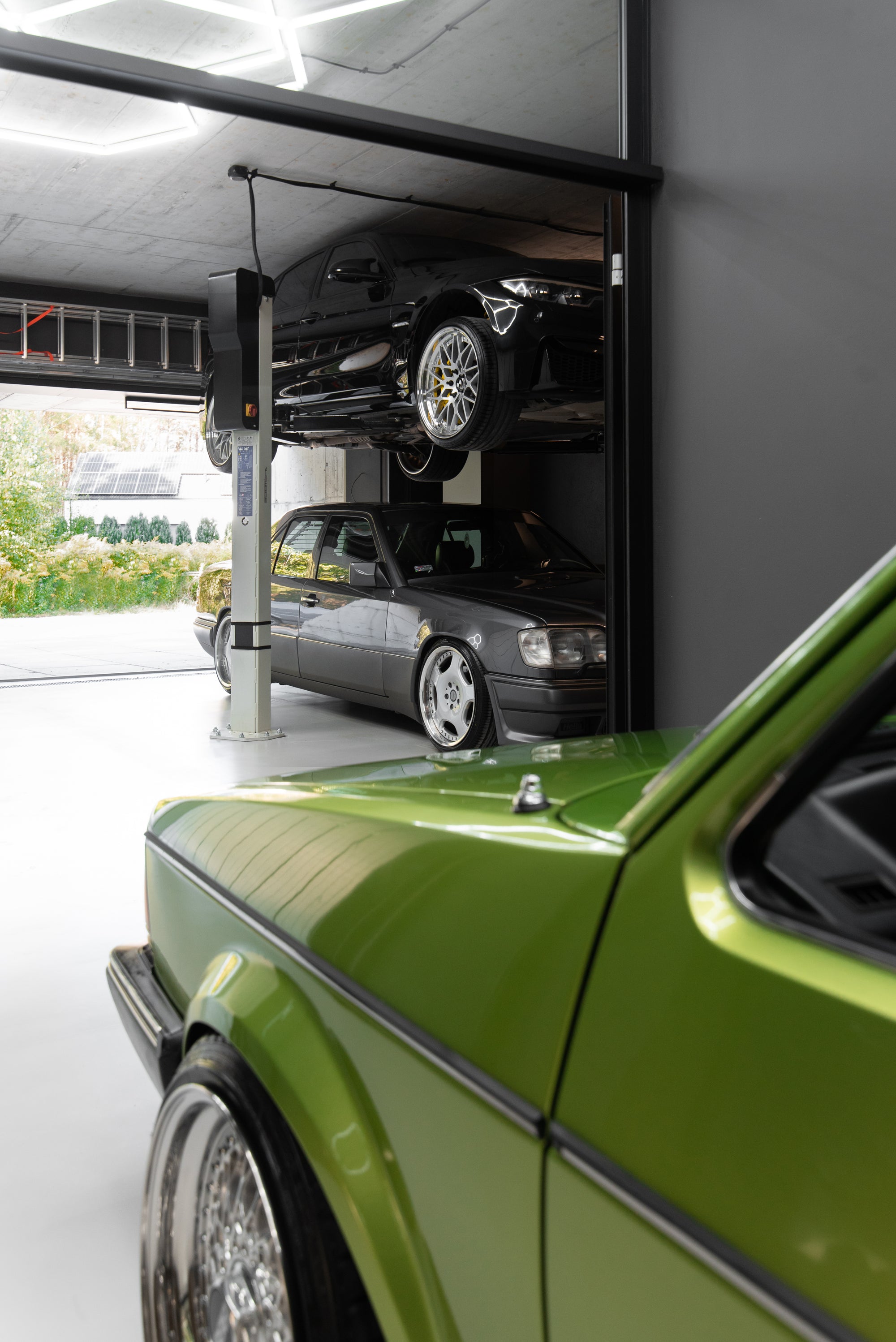Open garage view with car lift and Mercedes showing connection between interior and exterior