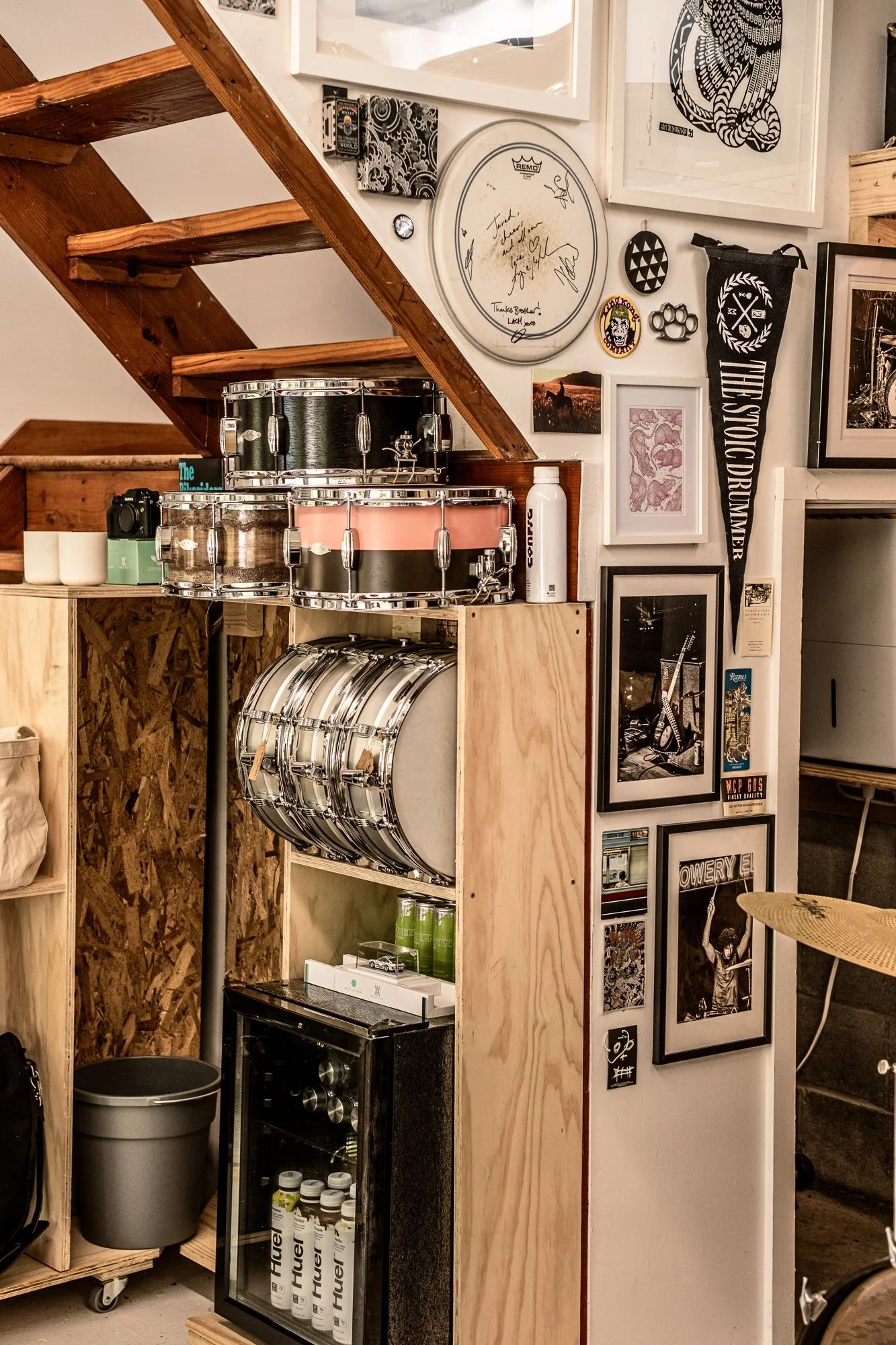 Music-themed garage with drum sets, framed pictures, and a staircase.