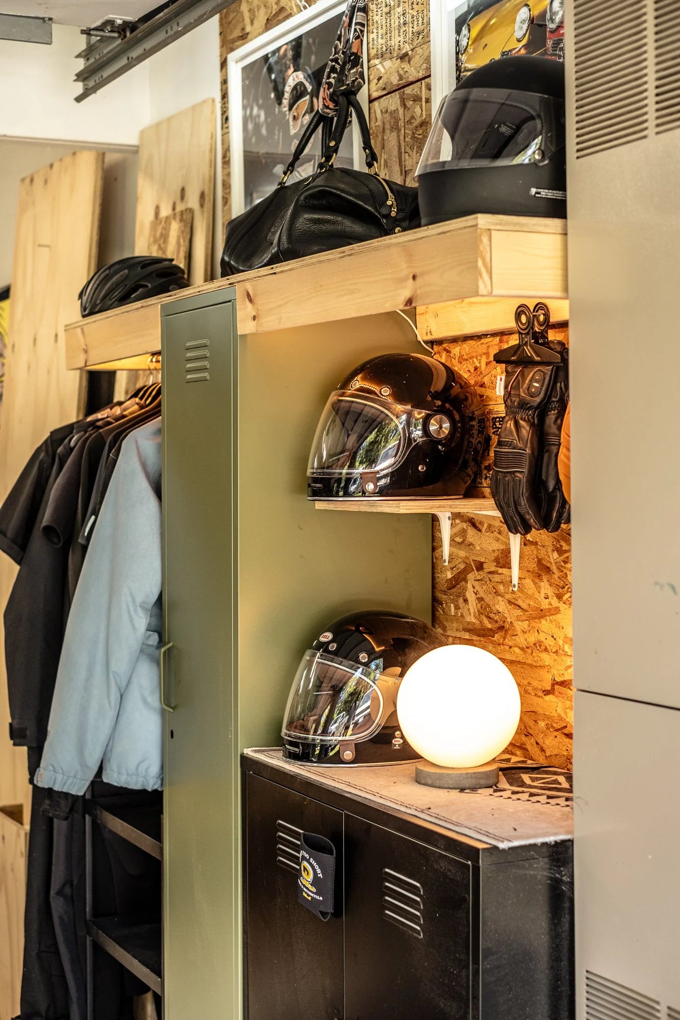 Motorcycle gear storage in a Hudson Valley garage, featuring helmets, gloves, and a black duffel bag.