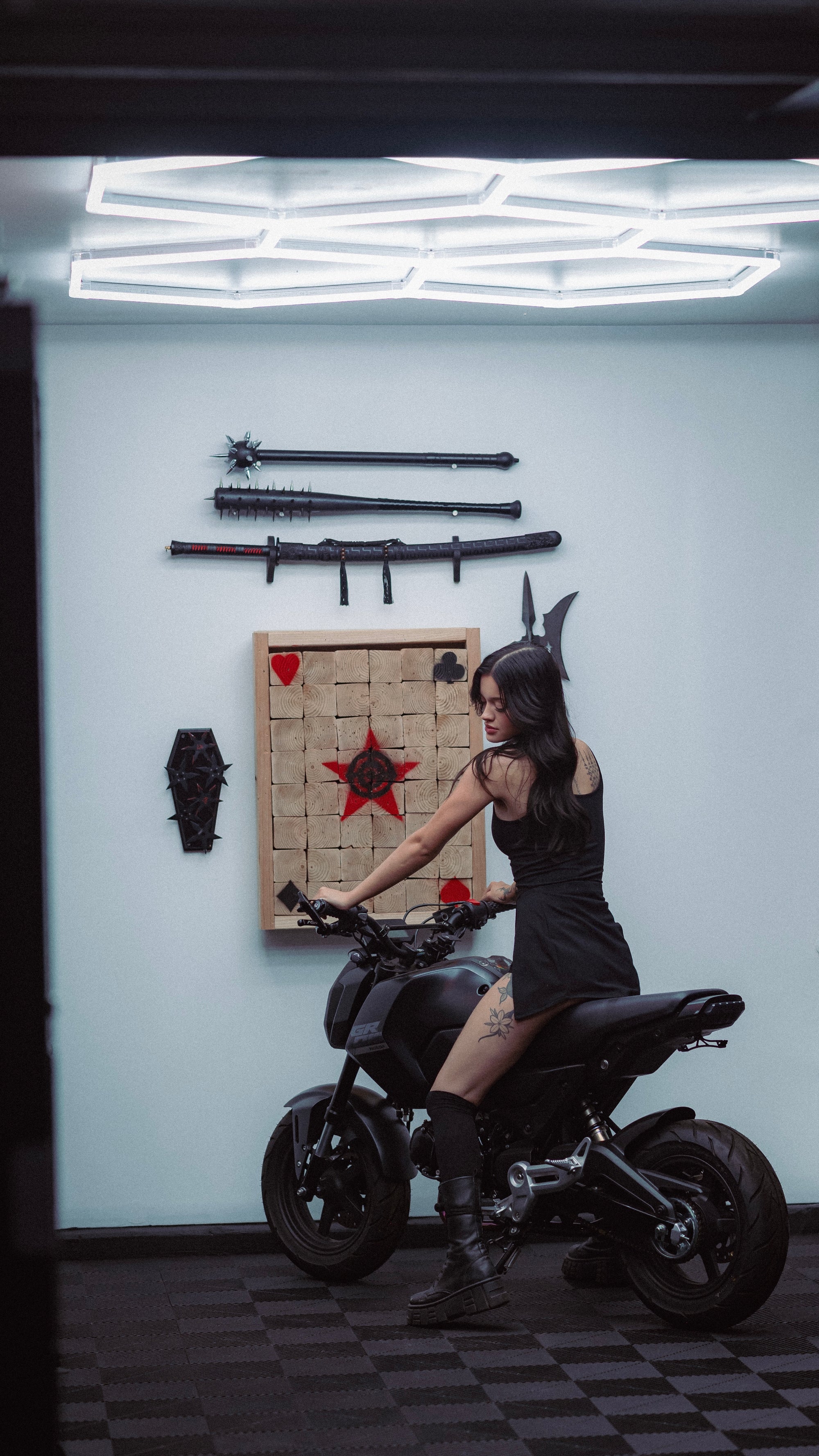 JDM garage wall display with mounted katanas, axe target board, and motorcycle in Las Vegas dream garage build