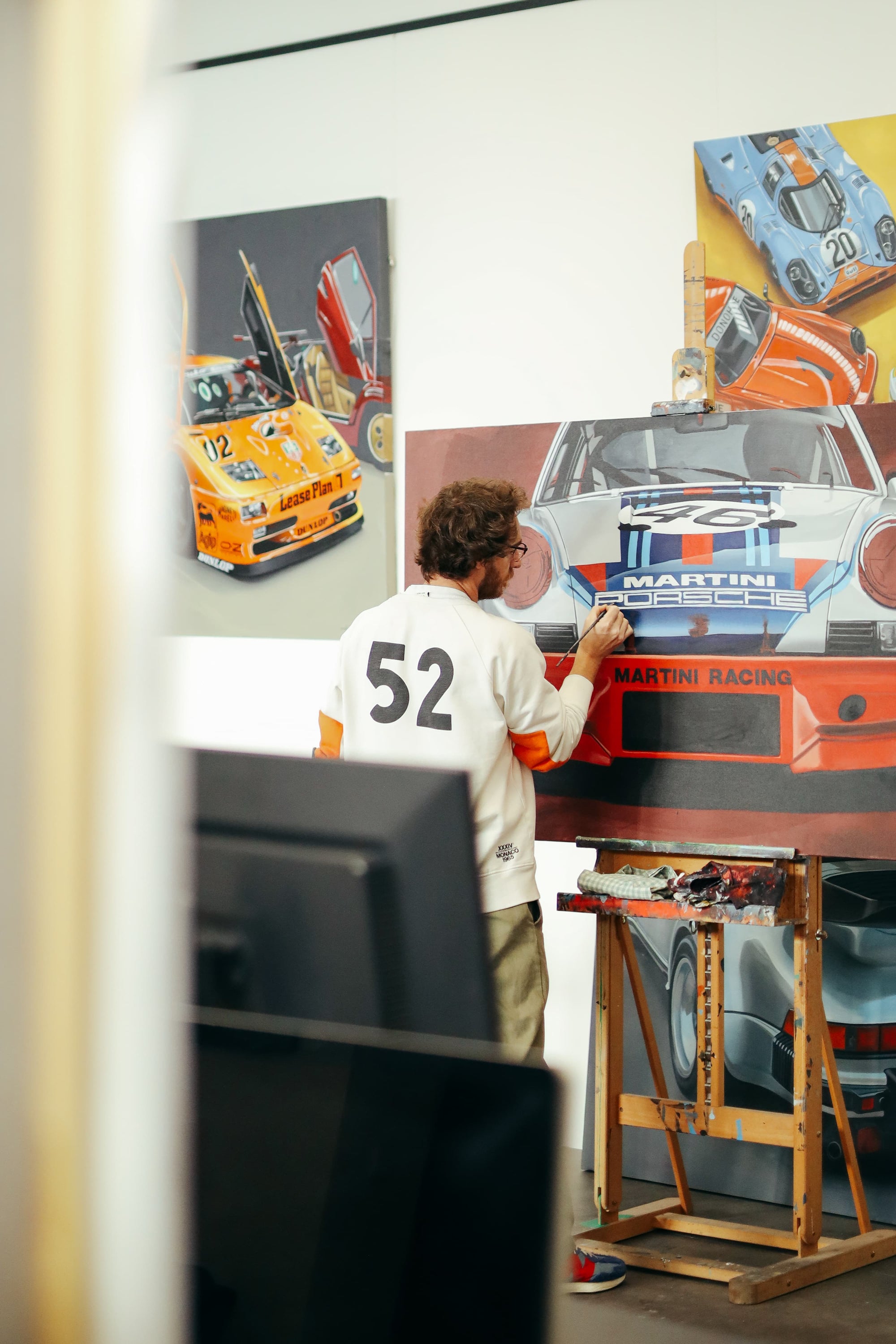 Artist Manu Campa painting a detailed Martini Racing Porsche 911 RSR in his Madrid studio.