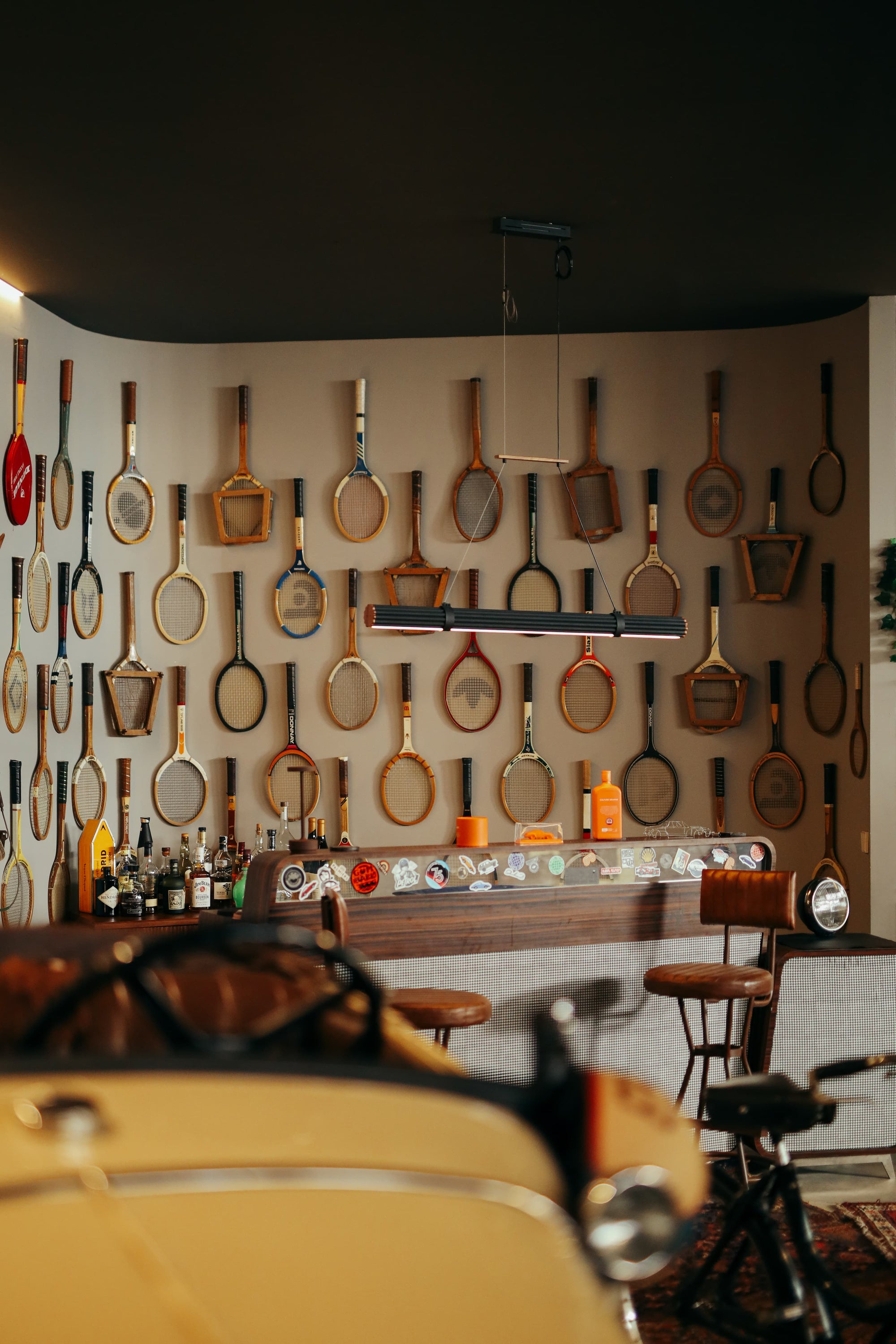 Vintage tennis rackets adorn a stylish bar in Manu Campa's Madrid garage studio.
