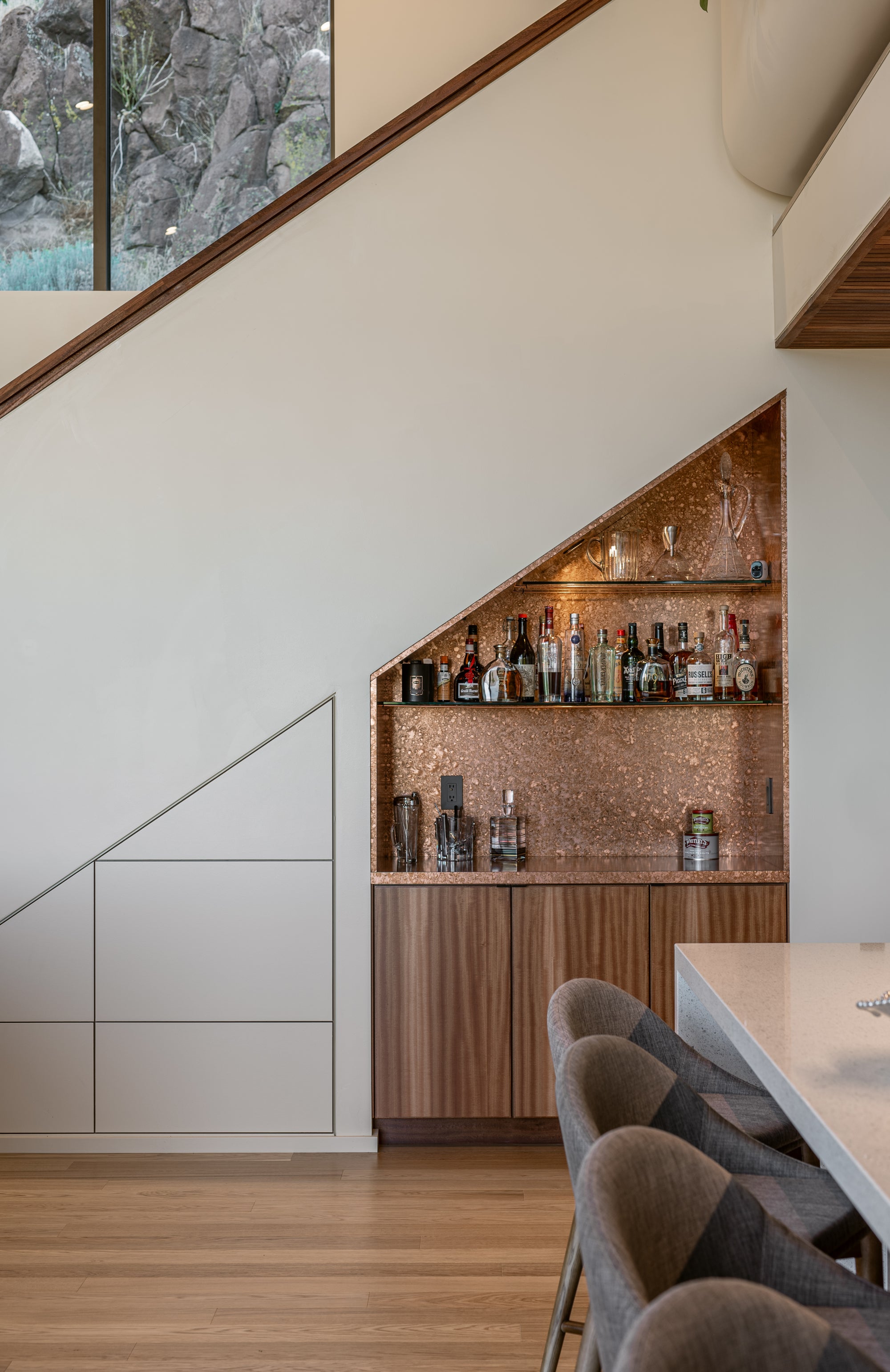 Modern home interior with custom bar detail and wood cabinetry connected to garage-focused living space