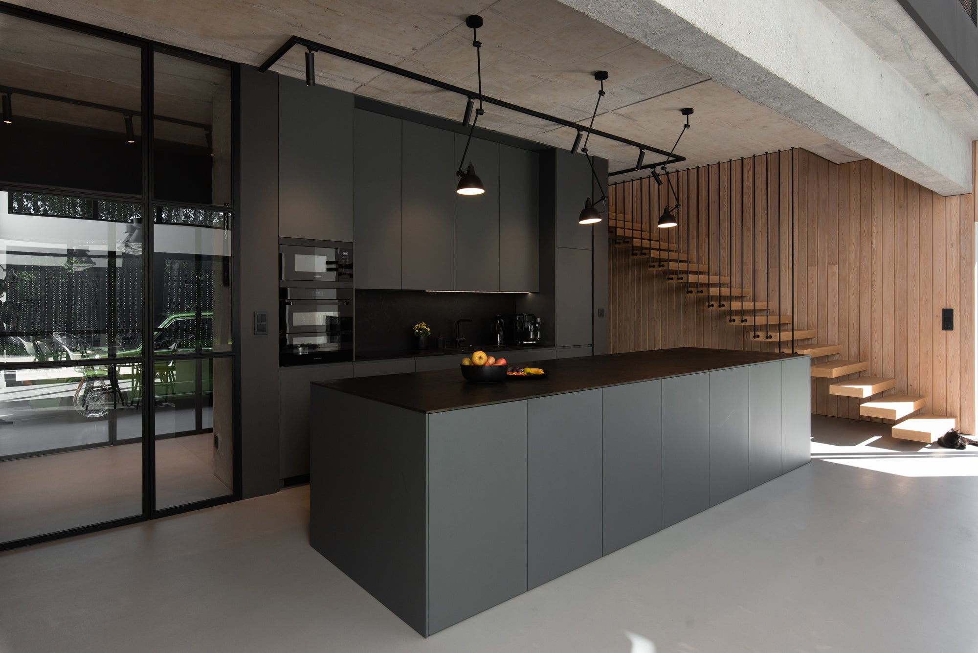 Volkswagen Golf seen through glass partition separating garage from interior living space