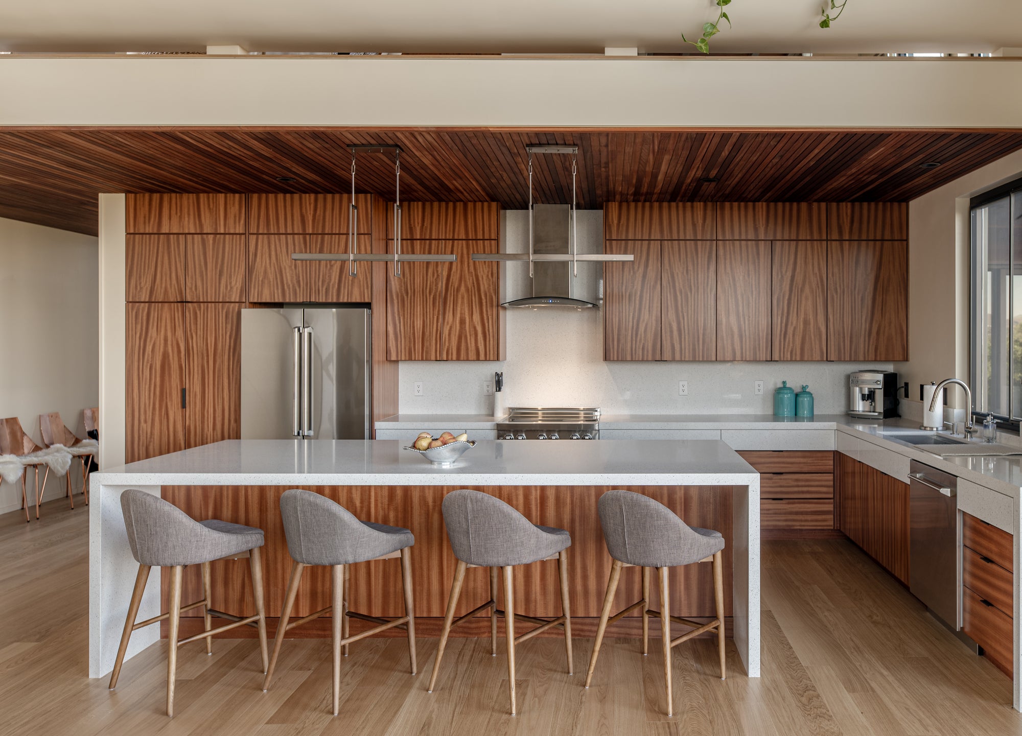 Modern kitchen with wood cabinetry in open plan home connected to garage and living space
