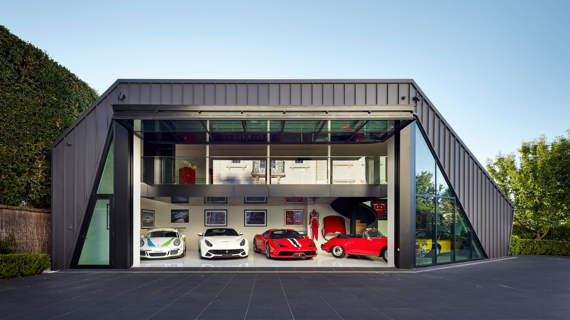 Modern luxury supercar garage with multiple Ferrari's and Porsche displayed inside
