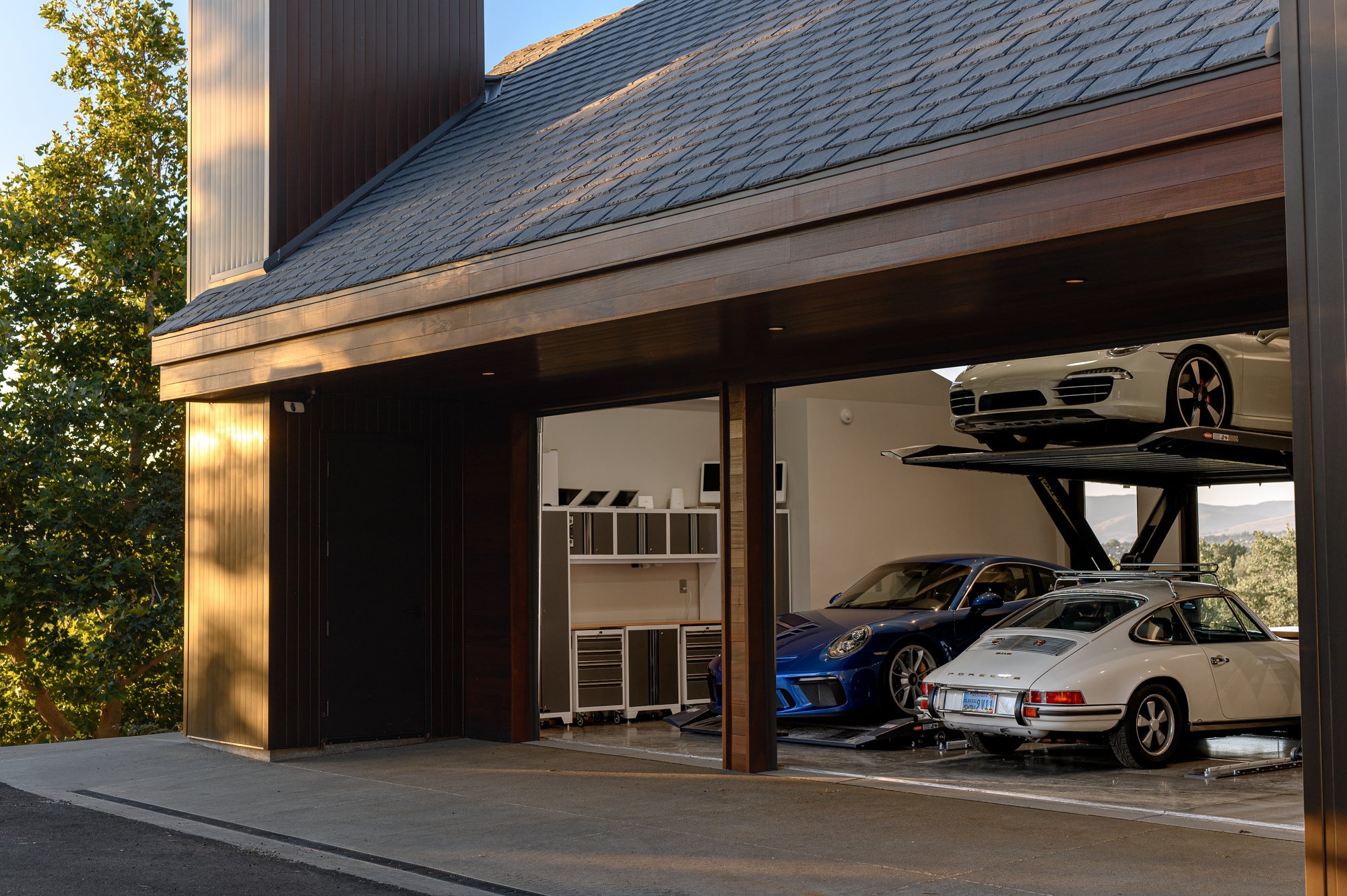 Multi car garage with Porsche collection and lifts designed for storage and accessibility