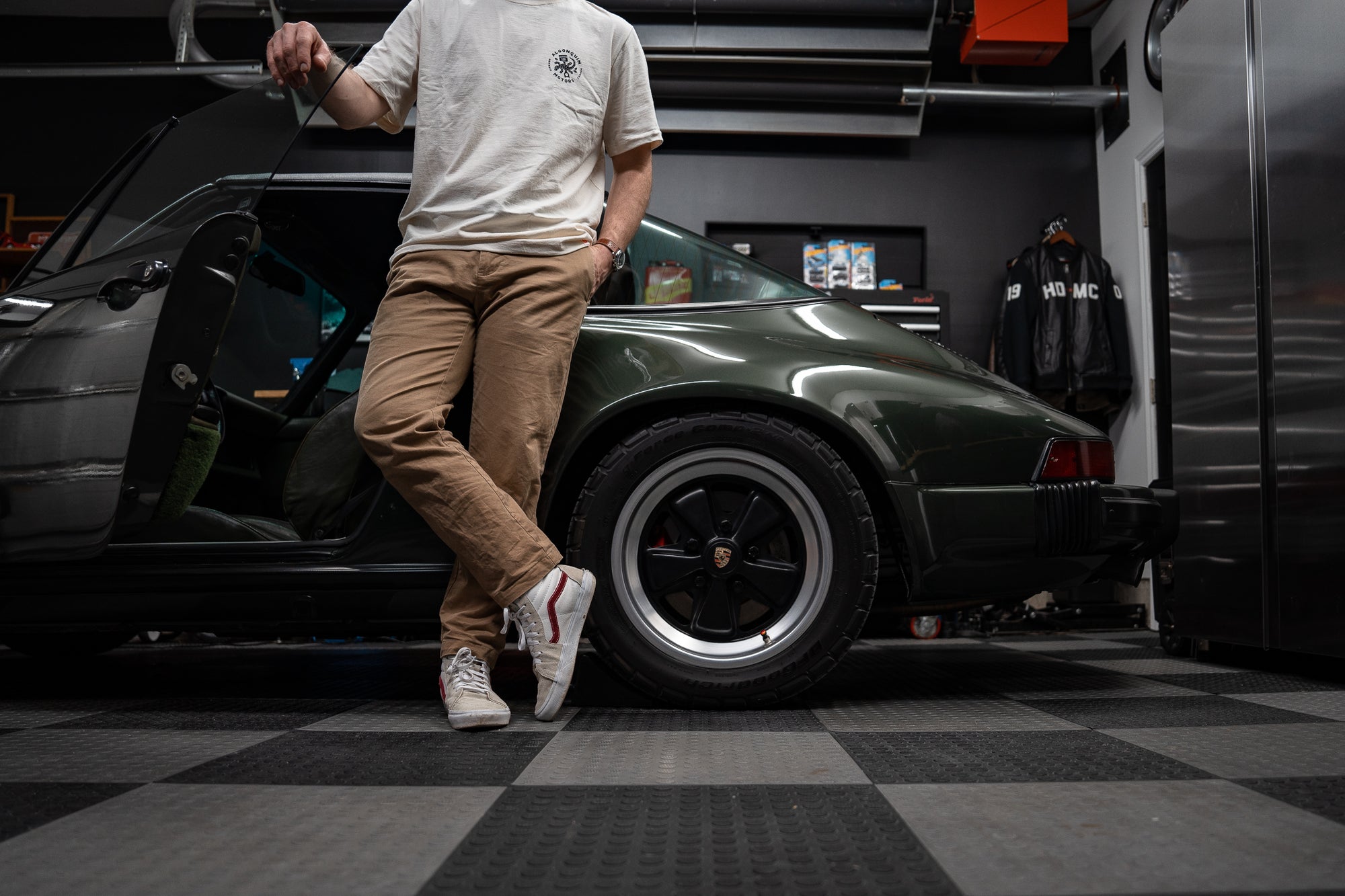 Garage owner leaning against a 1977 Porsche 911S Targa inside home garage
