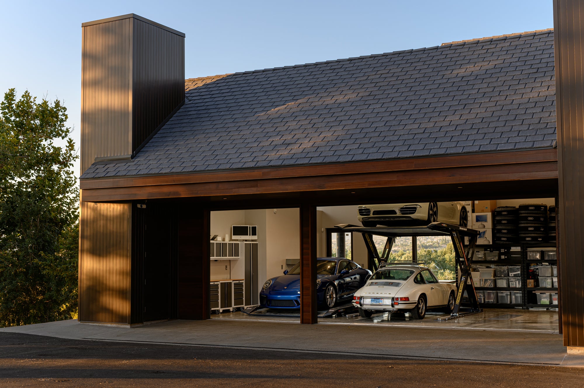 Porsche garage with storage wall and car lift creating a functional workspace for maintenance