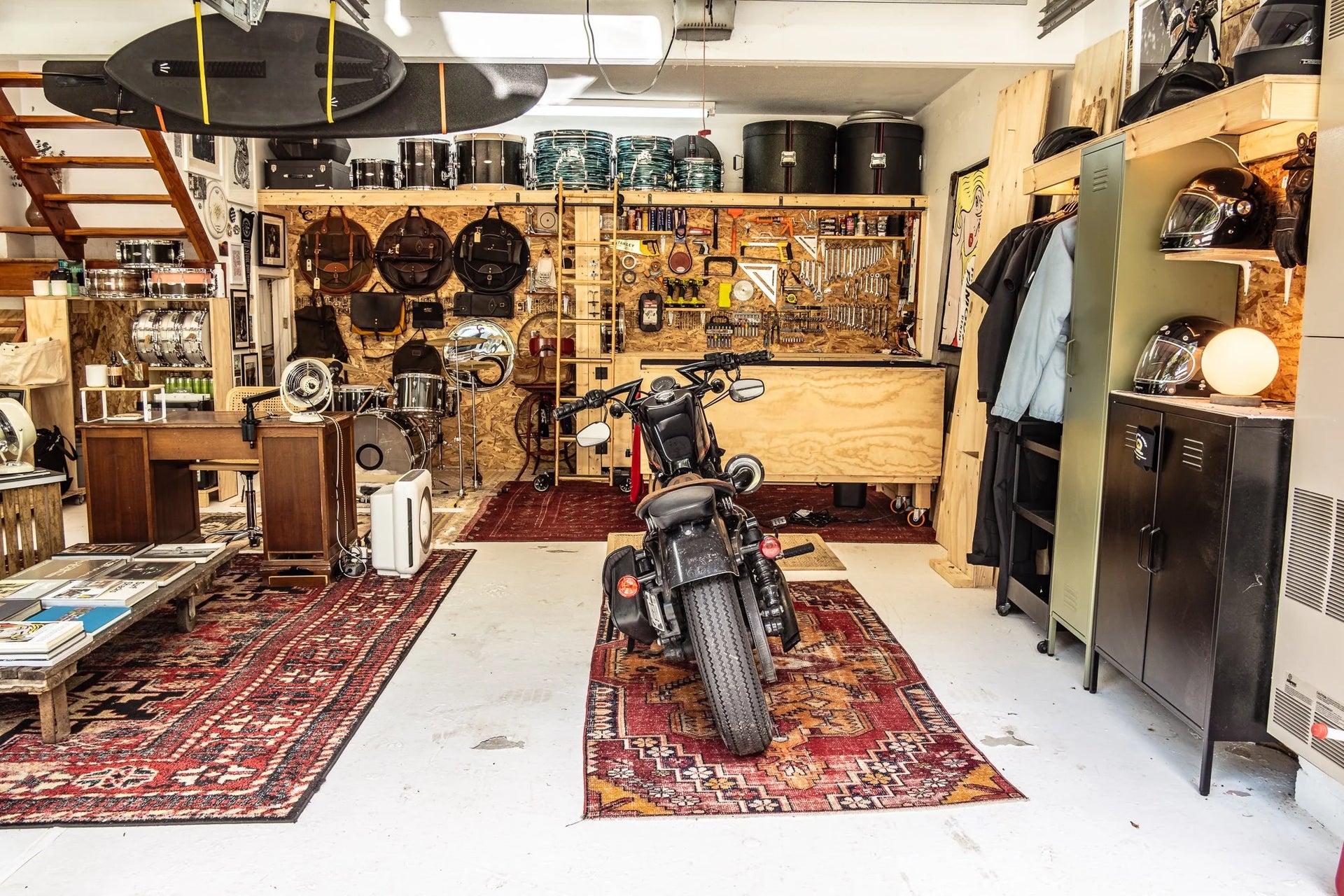 Spacious Hudson Valley garage workshop with Harley Davidson motorcycle, drums, tools, leather couch, and surfboards.