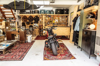 Spacious Hudson Valley garage workshop with Harley Davidson motorcycle, drums, tools, leather couch, and surfboards.