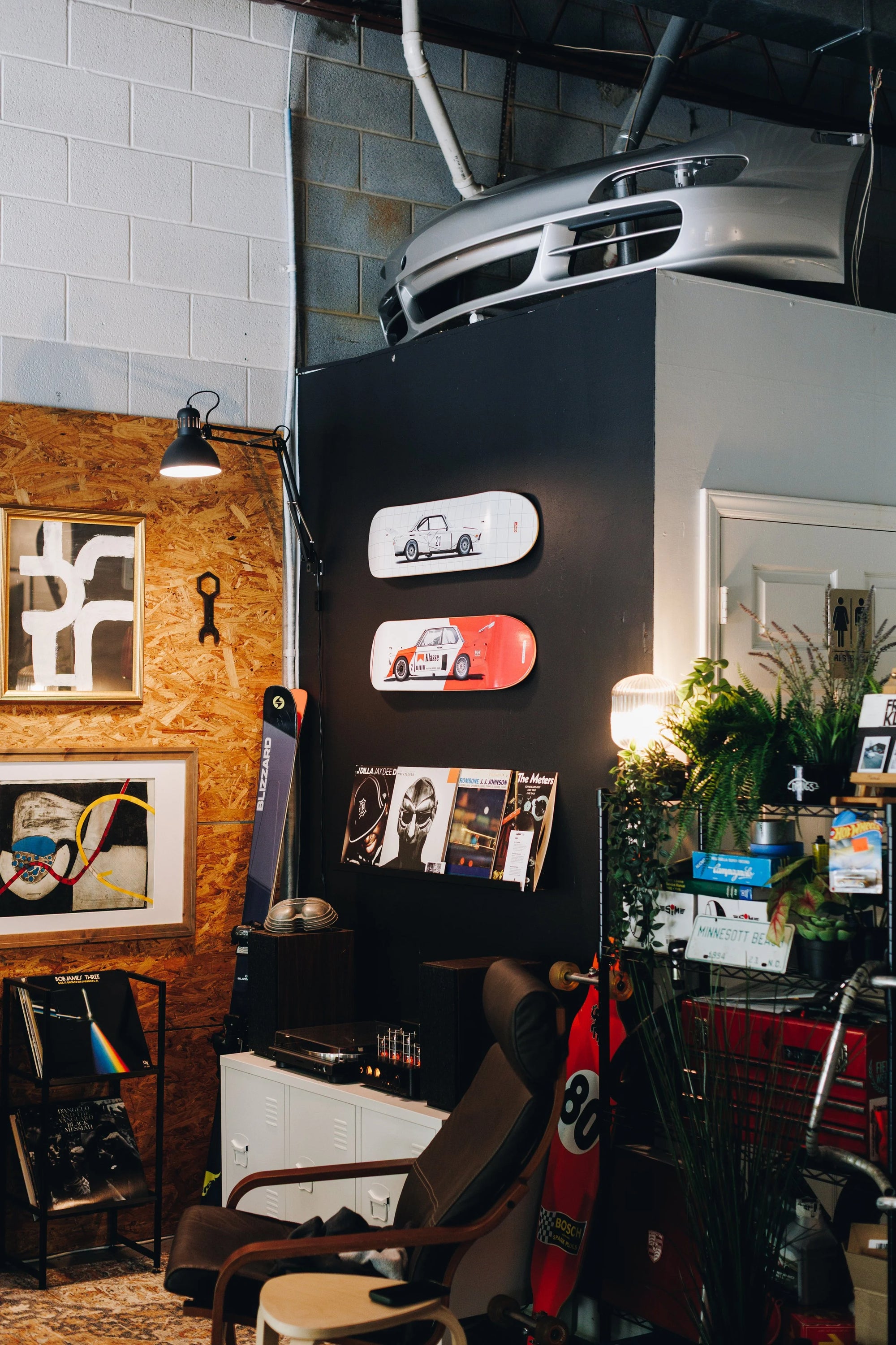 Interior of Werkstatt 80 garage with car parts, decor, and art on the wall
