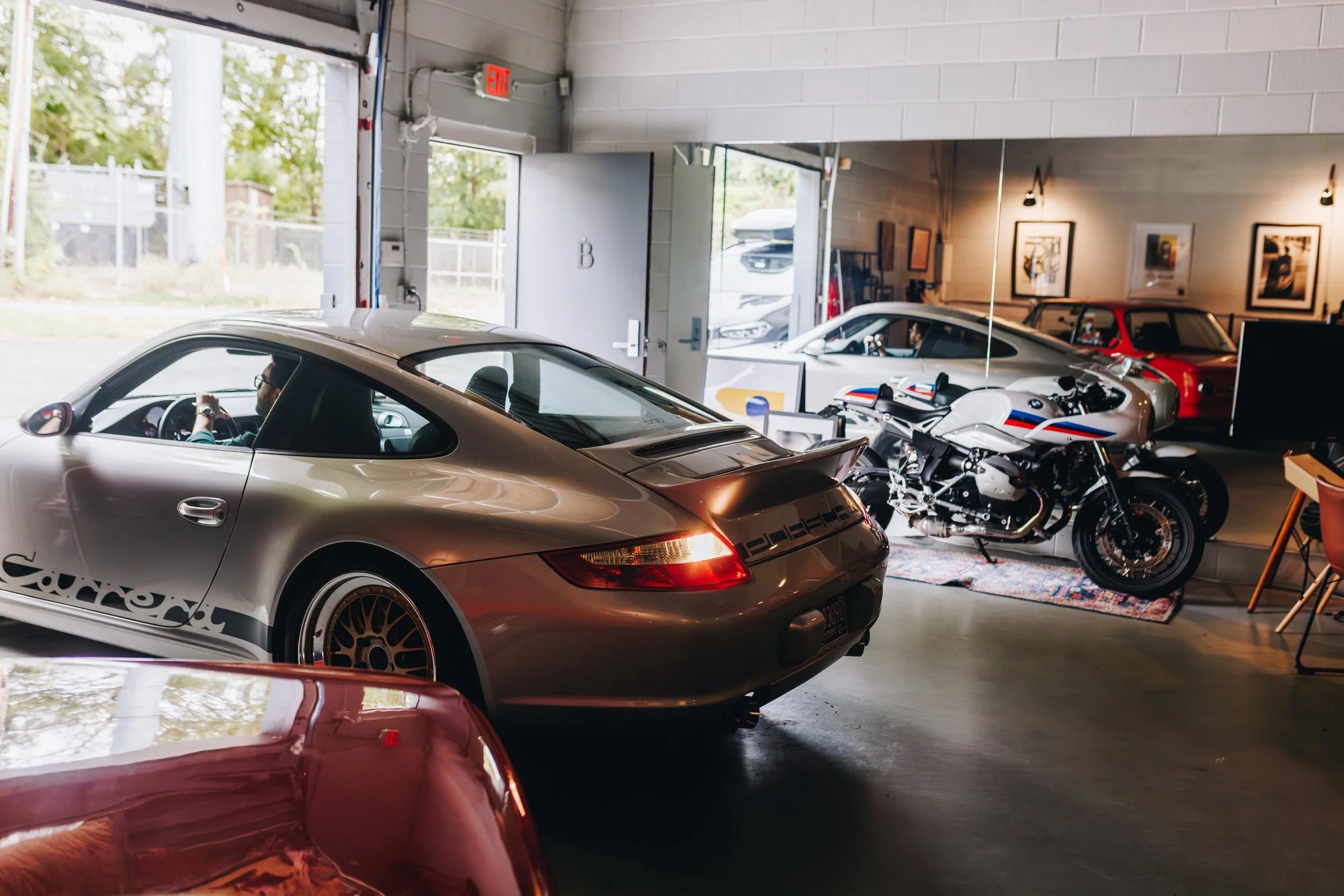 Porsche and BMW motorcycle in the Werkstatt 80 garage with reflections on the floor