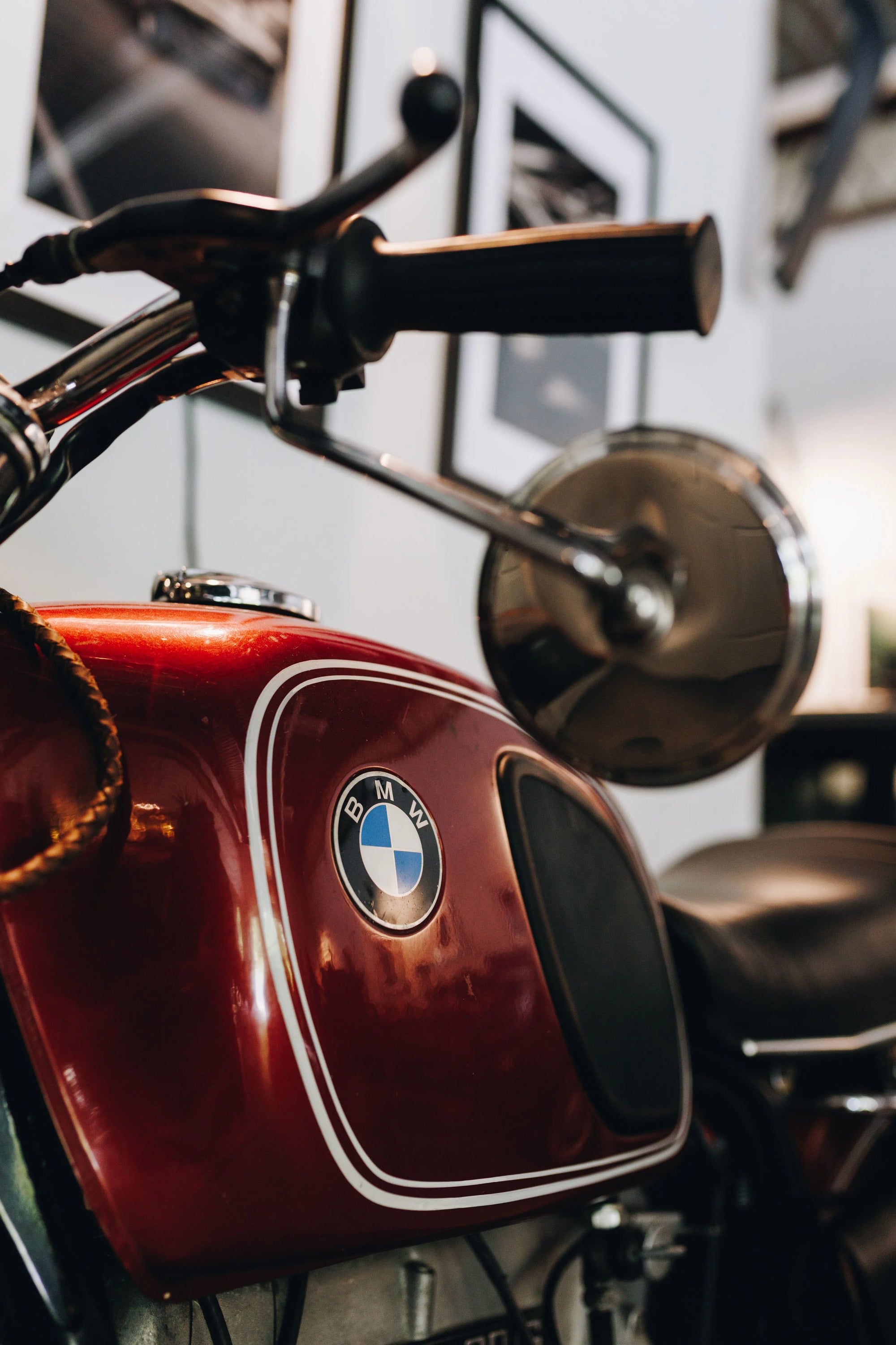 Close-up of a red BMW motorcycle with handlebar and mirror.