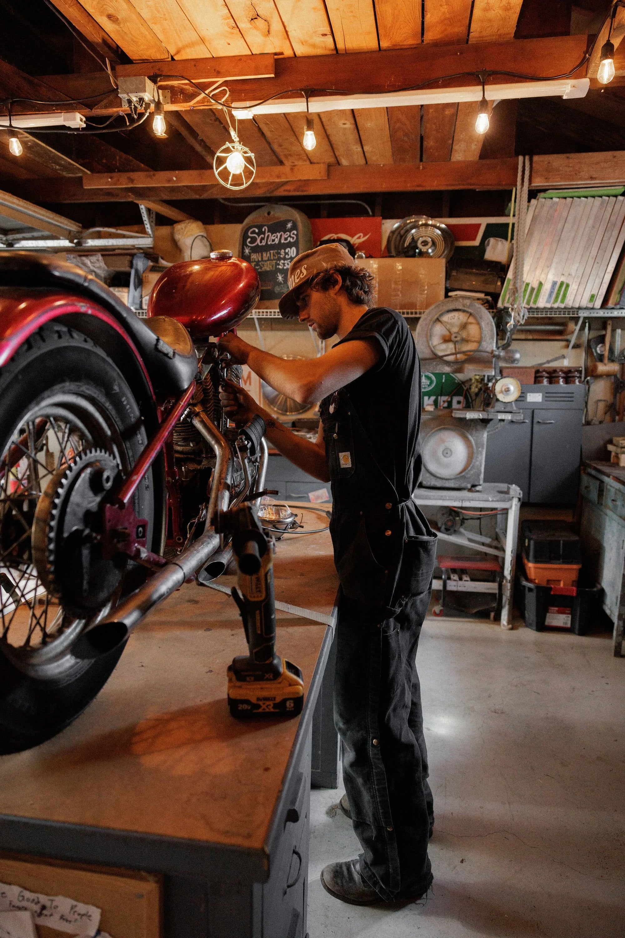Zander Roe working in his cluttered Northern California garage workshop with tools and car parts.